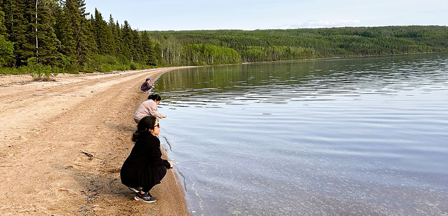 People releasing tobacco bundles into a northern lake