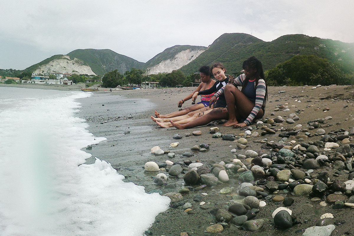 Three young women sitting on the beach