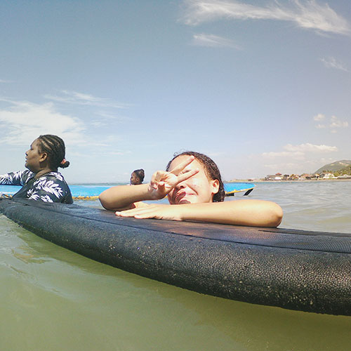 Two young women in the ocean on surfboards