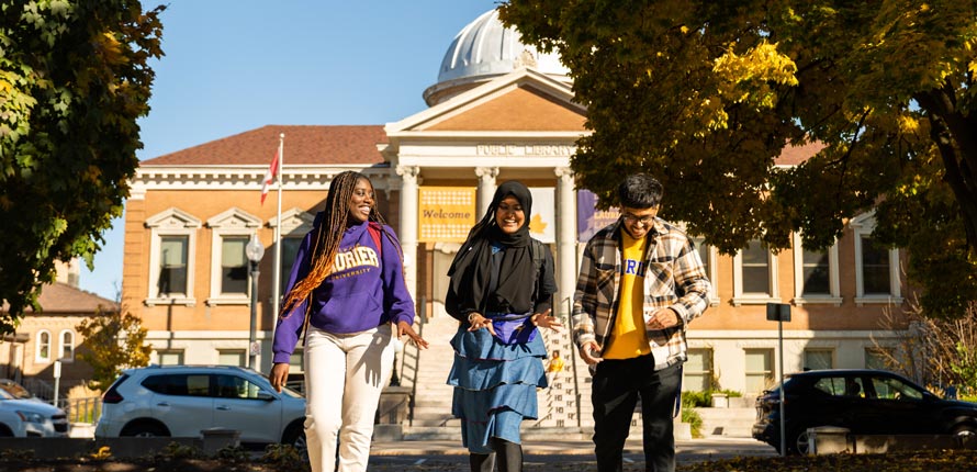 three students walking outside of canergie building
